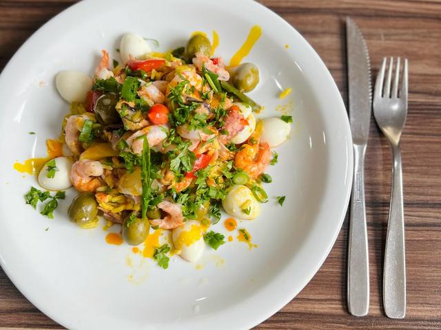 Salada montada num prato branco, com talheres (Instagram da casa)